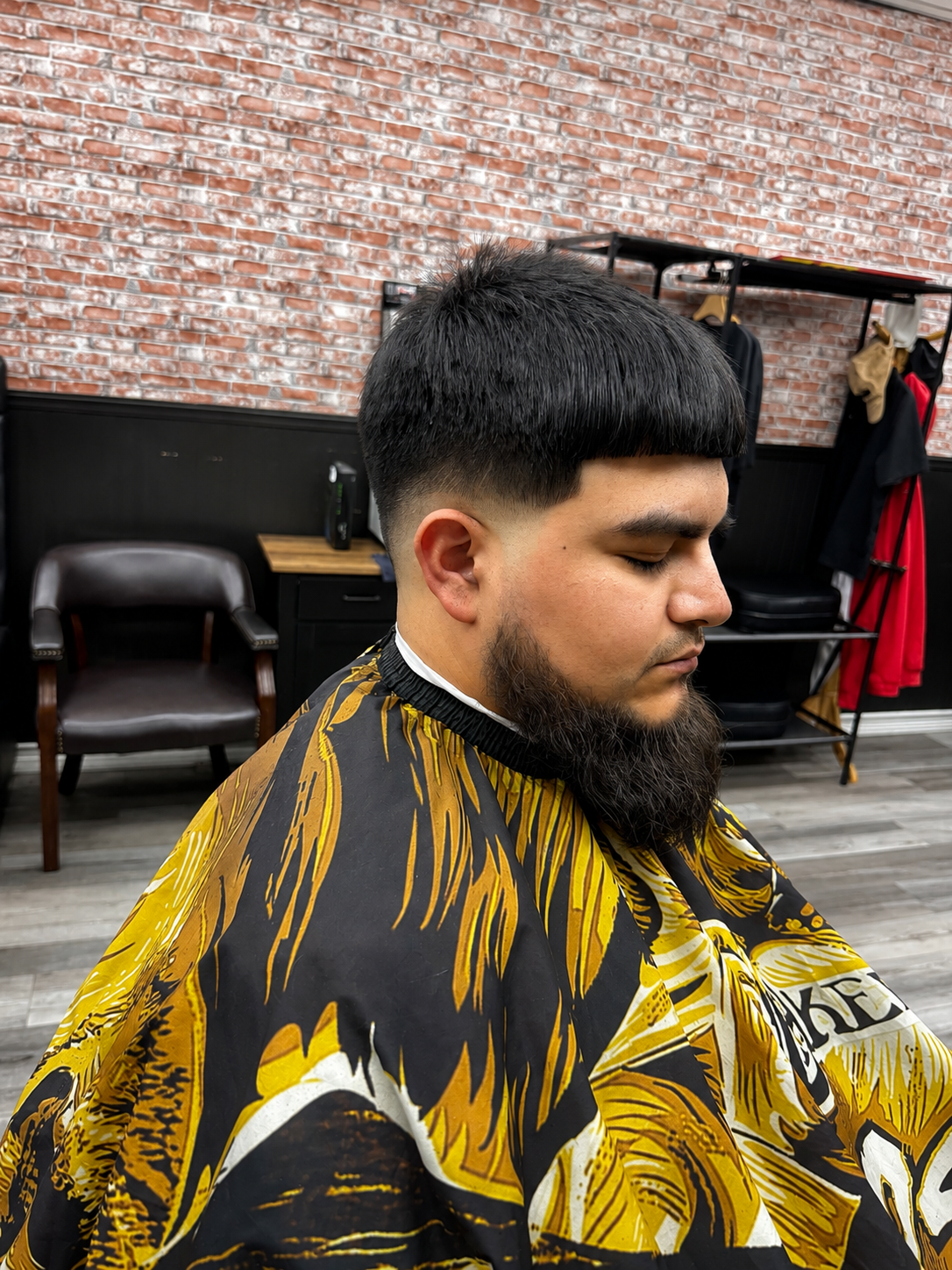 Textured mushroom cut with low taper fade and full beard