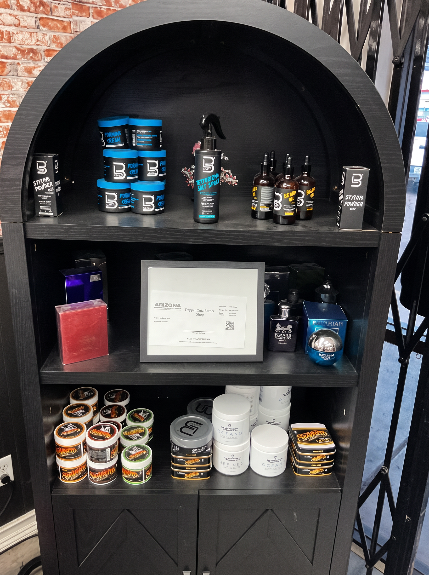 Shelf of grooming products, pomades and beard oils sold at Dapper Cuts Barbershop