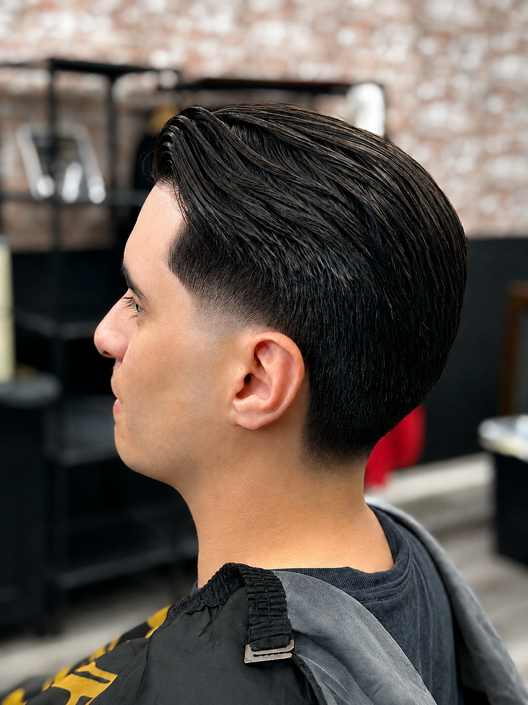 Slick back taper fade with clean neckline at Dapper Cuts Barbershop